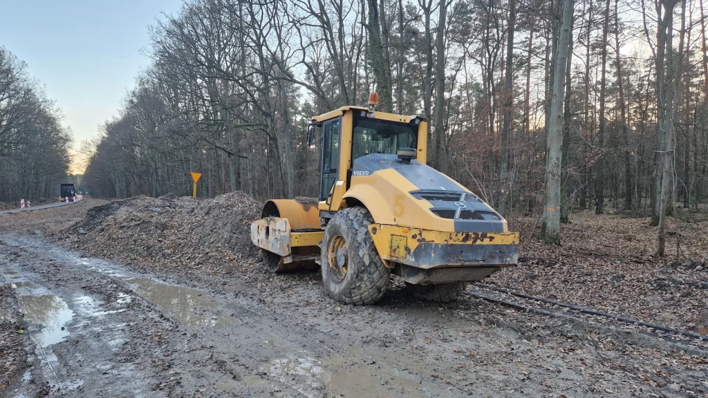 żółta koparka stabilizująca grunt podczas prac budowlanych